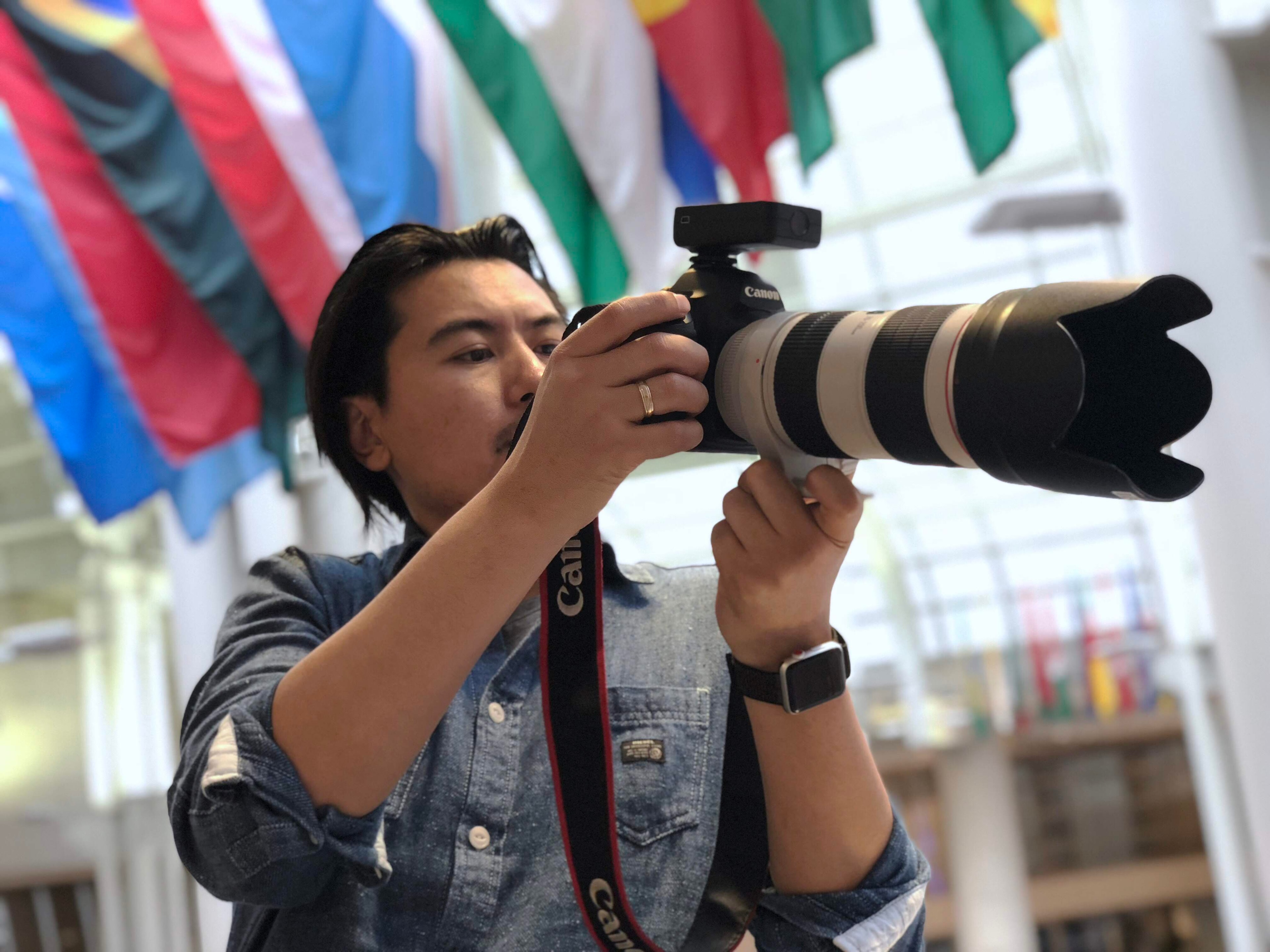 Tim Primkulov shooting with Canon telephoto lens
